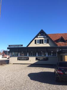 een gebouw waar een auto voor geparkeerd staat bij Blommenslyst Kro in Blommenslyst