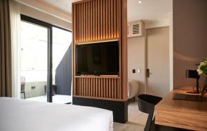 a bedroom with a television in a wooden cabinet at Lastarria Hotel in Santiago