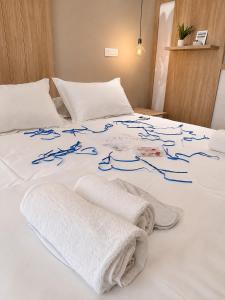 a white bed with blue writing on it at Le Onde Studio in Durrës