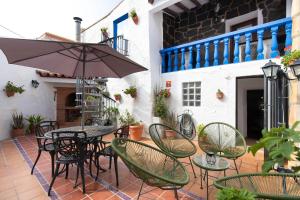 a patio with tables and chairs and an umbrella at Casa rural Casa Leles in Lagata