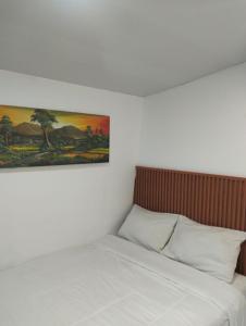 a bedroom with a bed with a painting on the wall at Hotel Sanrina Kuta Bali in Kuta +43 photos