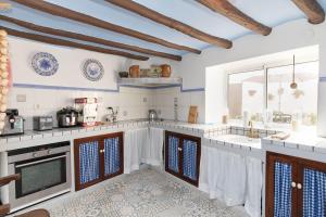 a kitchen with white counters and a large window at Casa rural Casa Leles in Lagata