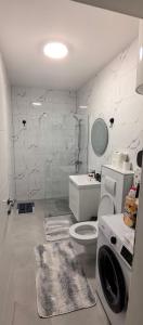 a white bathroom with a toilet and a sink at Apartman Vaske 2 sa GARAŽOM in Brčko