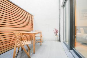 a wooden table and a chair on a balcony at Appartement en plein centre-ville in Liège