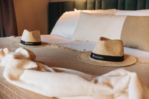 two hats are sitting on top of a bed at Legado Wine Lodge in Maipú