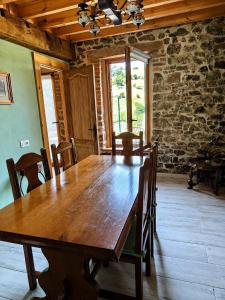 a dining room with a wooden table and chairs at El Llugar de las Drusas in Fontanina