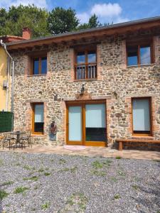 a stone house with windows and a patio at El Llugar de las Drusas in Fontanina