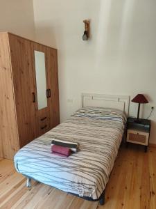 a bedroom with a bed with a wooden floor at El Llugar de las Drusas in Fontanina