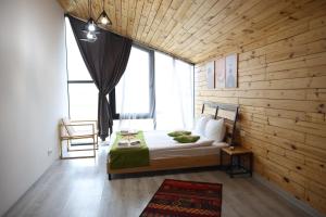 ein Schlafzimmer mit einem Bett und einem großen Fenster in der Unterkunft Kaghni Hotel in Dsegh