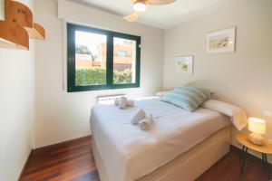 a bedroom with a large white bed with a window at WELCS CASA 423 PDA con piscina in Vall-Llobrega