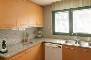 a kitchen with wooden cabinets and a sink and a window at WELCS CASA 423 PDA con piscina in Vall-Llobrega +24 photos