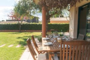 a wooden table with chairs and wine glasses on it at WELCS CASA 423 PDA con piscina in Vall-Llobrega