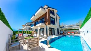 a villa with a swimming pool and a house at Villa Bella in Doger Koyu