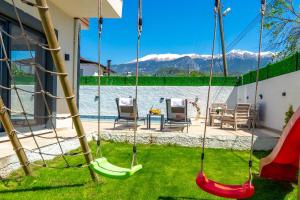 a backyard with swings and a view of the water at Villa Bella in Doger Koyu