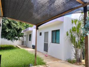 a house with a thatched roof and a yard at Cómo en casa in Tizimín