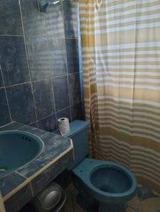 a bathroom with a blue toilet and a sink at Cómo en casa in Tizimín