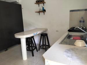 a kitchen with a sink and two bar stools at Cómo en casa in Tizimín