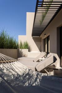 a patio with chairs and a hammock on the side of a house at Anthem Suites & Spa in Athens