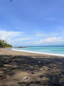 a beach with the sand and the ocean at Casa Colibrí #1 in Puerto Jiménez +3 photos