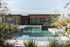 a swimming pool in front of a house at Legado Wine Lodge in Maipú