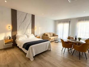 a bedroom with a bed and a table and chairs at La Serrería-Premium Suite Apartments & Private Jacuzzi in Belmonte +126 photos