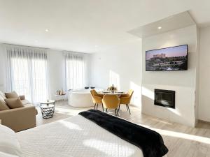 a bedroom with a bed and a living room with a fireplace at La Serrería-Premium Suite Apartments & Private Jacuzzi in Belmonte