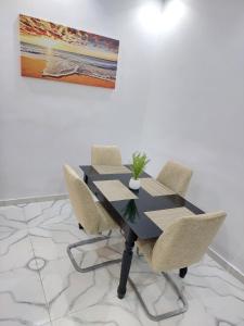 a dining room table with chairs and a painting at Horizon Bleu Cozy prés de la Plage avec Balecon in Dakar