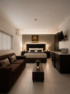 a living room with a bed and a couch at BoniM Guesthouse - aka Magisha Guesthouse in Nelspruit