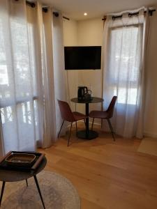 a living room with a table and chairs and windows at Le 400 BIS in Bourg-Saint-Maurice
