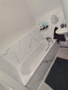 a bathroom with a white tub and a sink at Max-El's Home in Geispolsheim