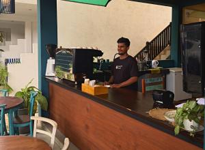 a man standing behind the counter of a restaurant at Santino Village in Mirissa