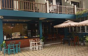 a restaurant with chairs and a bar with a balcony at Santino Village in Mirissa