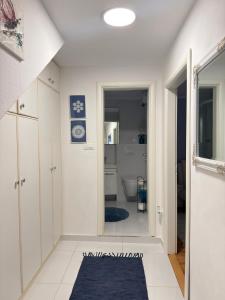 a bathroom with white walls and a blue rug on the floor at Apartman Luna in Šibenik