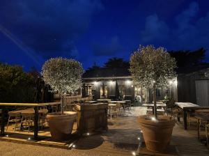 a patio with tables and trees at night at le Bistrot des Portes in Les Portes +11 photos