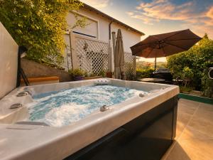 a jacuzzi tub in a backyard with an umbrella at PMC Traumblick Suite & Spa - Whirlpool & Sauna in Bad Ems