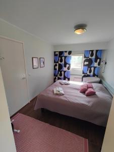 a bedroom with a bed with pink pillows on it at Wanha Mannila in Savonlinna