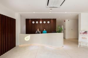 two people standing at a counter in a lobby at Alba Hotel in Hue
