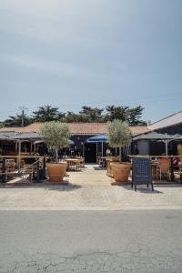 a patio with potted trees and tables and chairs at le Bistrot des Portes in Les Portes