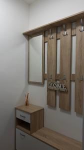 a bathroom with four mirrors and a wooden shelf at Urban Apartment Karpoš in Skopje