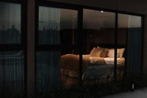a bedroom with a bed in a room with windows at Legado Wine Lodge in Maipú +1 photo