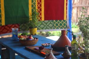 a table with a bowl of fruit and a basket of vegetables at Traditional Berber Eco Farm Stay in Agadir