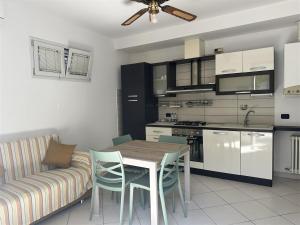 a kitchen and living room with a table and a couch at Frontemare in Porto Garibaldi