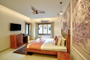 a bedroom with a bed and a flat screen tv at Ocean n' Sand - By Q23 Resorts & Suites in Candolim