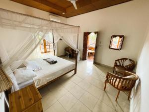 a bedroom with a canopy bed and a chair at Kubu Elsa Bali in Lovina +67 photos