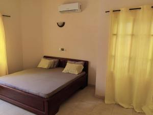 a bedroom with a bed and a window with a heater at Appartement 2 chambres salon in Cotonou