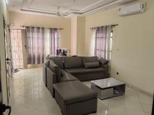a living room with a couch and a table at Appartement 2 chambres salon in Cotonou