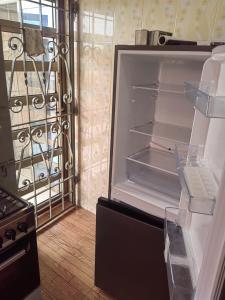 an empty refrigerator with its door open in a kitchen at Appartement 2 chambres salon in Cotonou