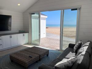 a living room with a couch and a view of the beach at SANDY BEACH Paradise On The Beach in Lincoln Junction