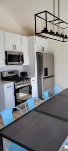 a kitchen with a black table and blue chairs at SANDY BEACH Paradise On The Beach in Lincoln Junction