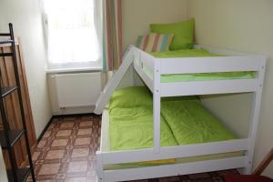 ein weißes Etagenbett in einem kleinen Zimmer in der Unterkunft Wohnstudio auf Schloss Semlow in Semlow